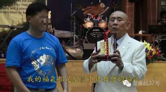 2015年夏令特会上，左坤接受黄金等礼物。 “血水圣灵”活动视频截图