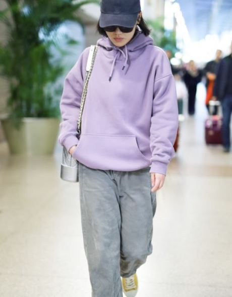 马思纯灰色阔腿裤和紫色卫衣搭配休闲低调,加上墨镜和棒球帽随性率真.