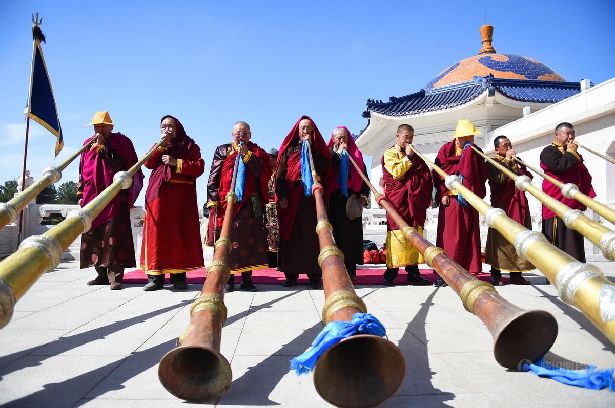 4月27日,宗教界人士在典礼上吹响法号.