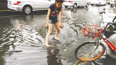 成都迎来瓢泼大雨 女孩光脚清下水道