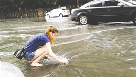 成都迎来瓢泼大雨 女孩光脚清下水道