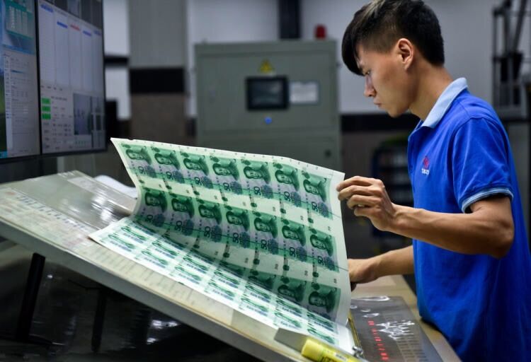 工人们在有序的忙碌着,一张张雪白的印钞纸摇身一变成为红红绿绿的