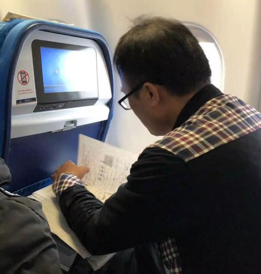 教师飞机上改试卷 网友神评论亮了!