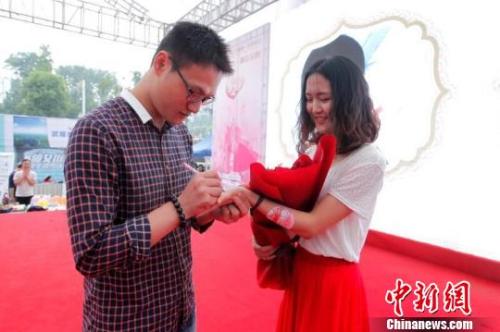资料图:一对单身男女在相亲会活动现场进行<a href= 晚婚族越发庞大 如何看待“男大当婚女大当嫁”?
