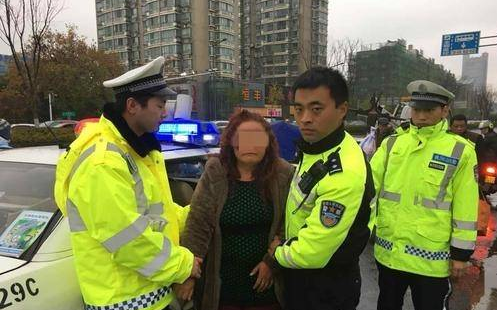 女司机逆行拖交警 强行冲过路口逃逸